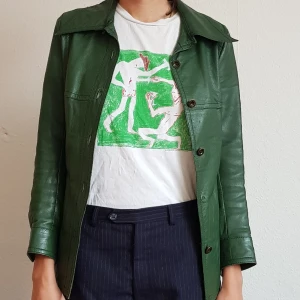 Grön skinnjacka 70tal - Vintage skinnjacka i bra kvalitet. Jag är 180cm och har strl 38, men den passar nog bättre på 36. Saknar en knapp näst längst ner.
