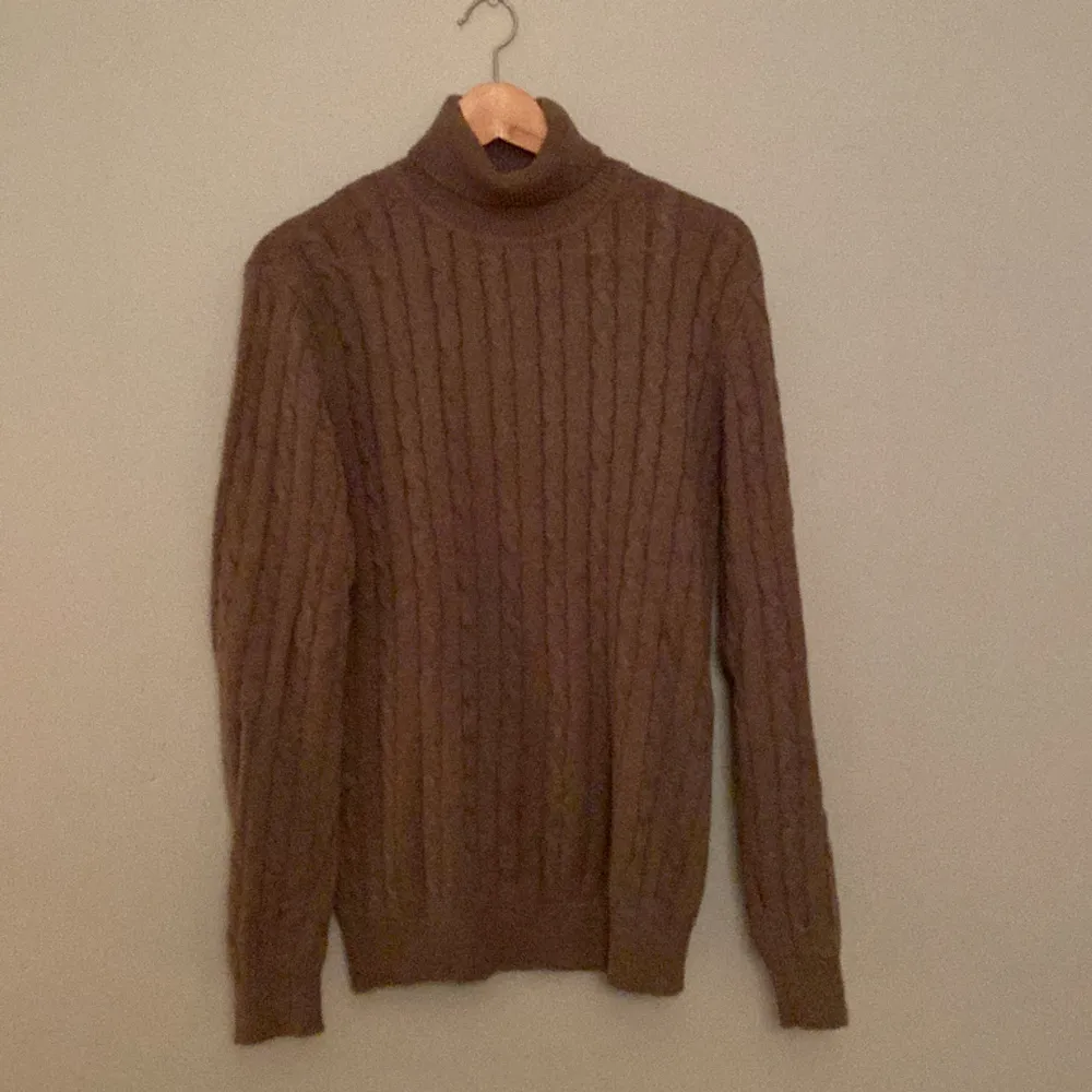 En grå/brun (taupe) polo/turtleneck tröja  från varumärket John Henric. 100% bomull  Kabelstickad  Tröjan är i mycket gott skick (9/10). Tröjor & Koftor.