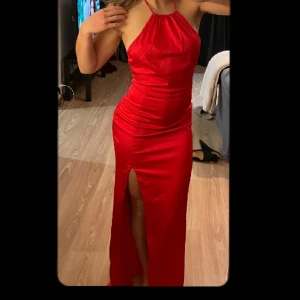 Röd långklänning/ balklänning  - Röd satin lång kläning. Öppen rygg. Köpt på Nelly. Använt 1 gång på min avslutning 