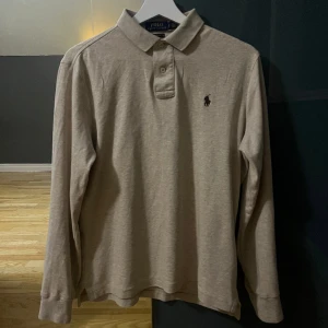 Ralph Lauren Piké långärmad - Säljer nu min beige Ralph Lauren långärmad piké då garderoben behöver plats och den är lite för liten. Finns inga defekter överhuvudtaget och den är så gott som ny, skulle passa den som är mellan 170cm-180cm skulle jag säga.