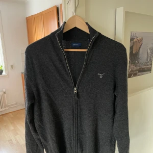 Gant zip cardigan - Tja! Säljer en cardigan från gant! Den är stickad i extra fine lambswool. Storleken är M men skulle säga att den passar S med. Nypris är 1200kr. Vårt pris 499kr!