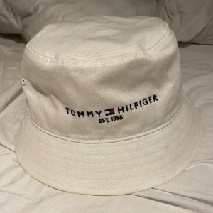 Tommy Hilfiger hatt - Vit Tommy Hilfiger hatt köpt på Tommy Hilfiger i butik påse finns. Köptes för 500 pris kan diskuteras.