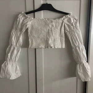 Vit croppad blus från NAKD - Säljer denna långärmade vita blusen från NAKD i storlek S/36. Använd 2 gånger. Inga defekter