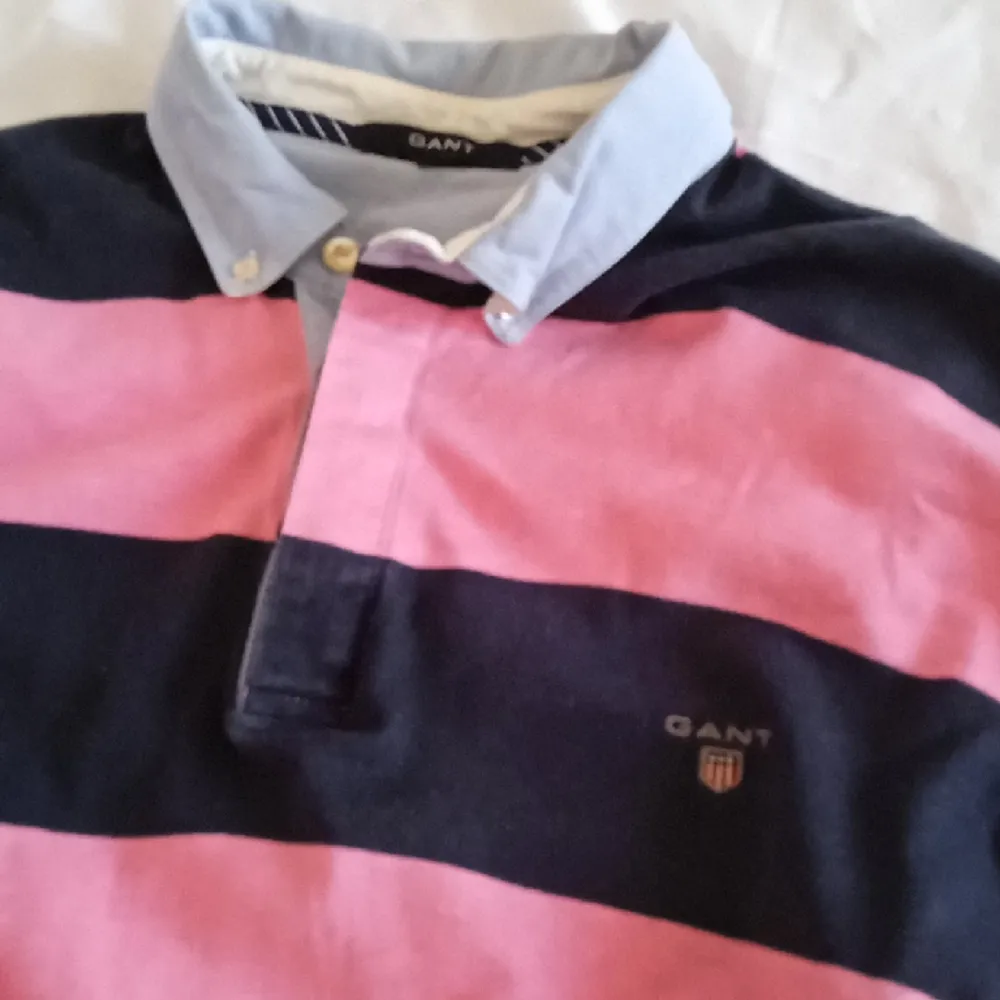 Mörkblå/rosa randig tröja från GANT. Strl 3 XL. 3Knappar vid halsen. Upplevs inte så stor. Tröjor & Koftor.