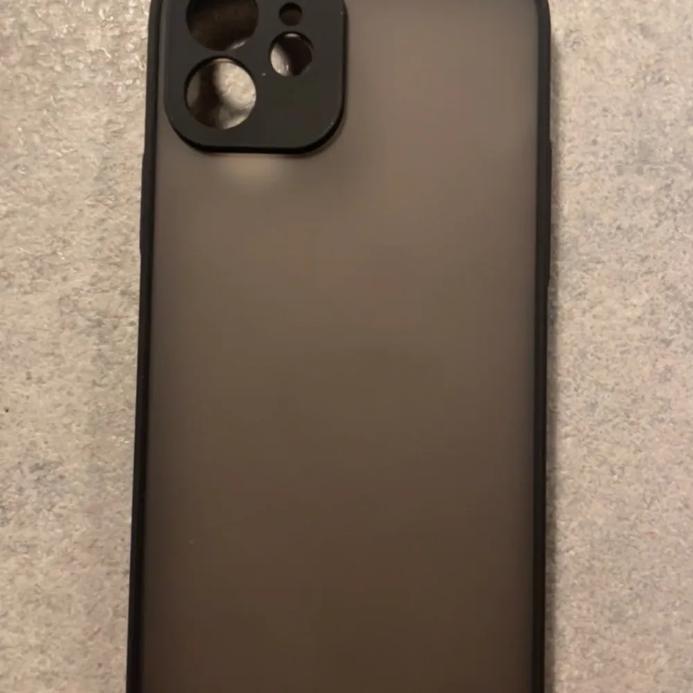Ett helt nyt mobil skal det är riktigt snyggt och still rent med svart gummi på sidorna och matt svart plast på baksidan skalet passar iPhone 12. Accessoarer.
