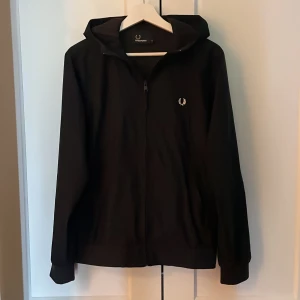 Fred Perry jacka - Mörkblå Fred Perry jacka. Jackan är i mycket bra skick och har inga hål eller slitage. Nypris ligger på omkring 2 200 kr.
