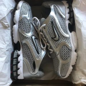 Nike Zoom Spiridon Cage 2 - Riktigt läckra Nike Spiridon Cage 2 i silver/grå/röd som jag tyvärr måste sälja då de ej passade mina fötter bekvämt nog! Köpte de i nyskick för 2400 och rj använt de sen dess! Hör genast av dig vid funderingar :)