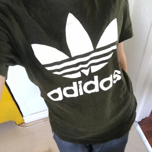 mörkgrön adidas t-shirt - En snygg mörkgrön adidas T-shirt med lite retro stil. Bra skick
