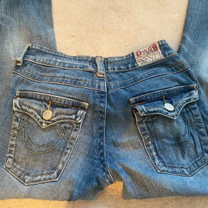 low waist bootcut jeans - Ett par lågmidjade jeans med knappar på backfickan, midjemåttet är ca 36 cm och innerbenslängden är 80 cm,  passar mig perfekt som brukar ha XS/S eller 34-36 på byxor, byxorna är lite långa på mig som är 160 cm