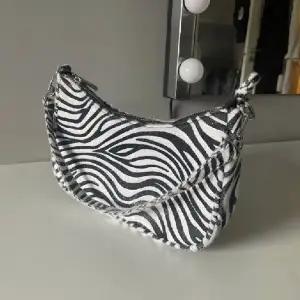 Unik väska i zebra mönster, passar till allt då den bryter fint 