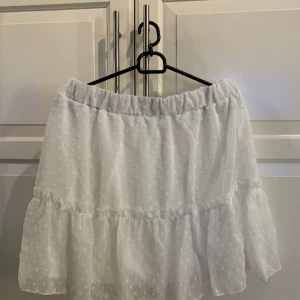 Vit kjol - Säljer denna fina kjol då jag råkat köpa 2. Den har ett prickigt mönster och är i storlek L men kan även passa en M då den har ressor i midjan. 