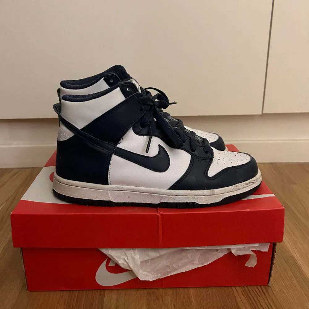 Höga Nike dunks i färgen white/midnight Navy, köpta 2021 och ganska sällsynt färg. Köpta för 2000, finns vissa slitningar men inget tydligt då de är sparsamt använda.. Skor.