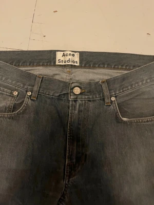 Gråa raka jeans från Acne Studios - Snygga grå jeans från Acne Studios med klassisk femficksmodell och raka ben. Jeansen har en diskret tvättad look och är tillverkade i denim. Perfekta för en stilren och avslappnad outfit.
