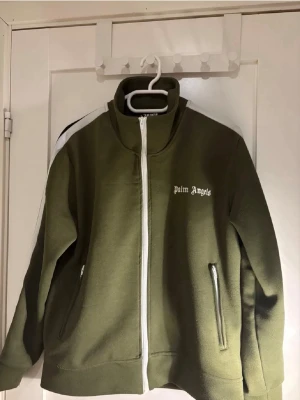 Olivgrön zip från Palm Angels - Säljer en olivgrön zip från Palm Angels. Knappt använt den så skicket är bra säljer pga att den inte passar mig längre. Säljer billigt då jag behöver pengar fort. Vid funderingar är det bara att ställa frågor!