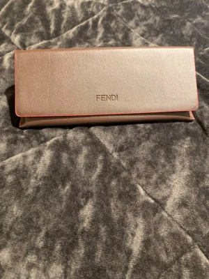 Fendi solglasögon med metallbåge - Snygga solglasögon från Fendi med smal, rektangulär form och mörka linser. Bågarna är i metall och kommer i ett elegant fodral med Fendi-logga. Perfekt accessoar för dig som vill ha en exklusiv och trendig look.//jag vill sälja den på grund passar inte min form