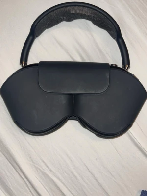 Apple AirPods Max hörlurar svart - Snygga och moderna Apple AirPods Max hörlurar i svart färg med smart skyddsfodral. Over-ear design med robust aluminium och mesh-material på huvudbandet för extra komfort. Perfekt för dig som vill ha grymt ljud och stilren look.