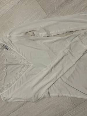 Intimissimi långärma - Säljer ett vitt nattlinne med långa ärmar och vacker spets längs urringningen. Materialet känns mjukt och bekvämt, perfekt för mysiga kvällar hemma. Spetsen ger en romantisk touch och nattlinnet har en klassisk, feminin design.