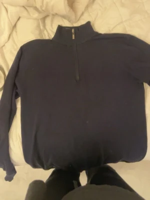 Mörkblå halvzip tröja från Wise - Mörkblå stickad tröja från Wise med halvzip och hög krage. Tröjan har långa ärmar och ribbade muddar vid ärmslut och nederkant. Perfekt för lager på lager och enkel att matcha med jeans eller byxor. Pris kan diskuteras 