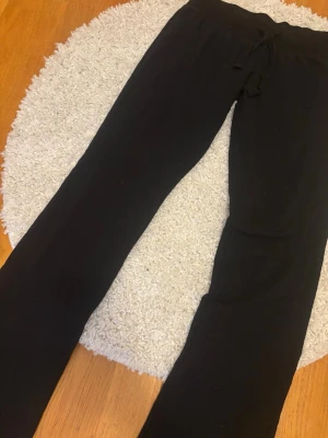 Svarta mjukisbyxor med dragsko - Ett par svarta mjukisbyxor med rak passform och dragsko i midjan. Tillverkade i mjukt material som känns skönt mot huden.