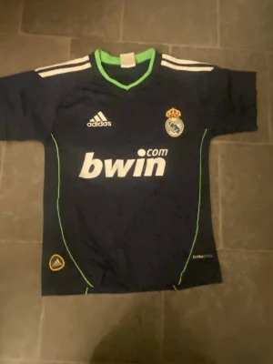 Adidas Real Madrid match törja  - Det är en svart vit fotbollströja och laget heter Real Madrid och tröjan är Retro med nummer 23