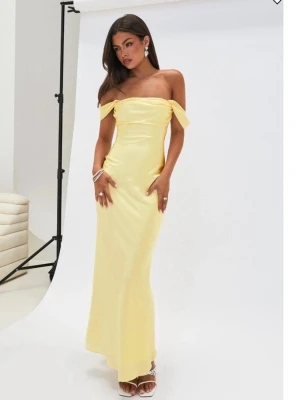 Ljusgul offshoulder balklänning i satin - Elegant ljusgul långklänning med offshoulder-design och figurnära passform från Princess Polly. Helt ny, säljer pga att den inte passa. All original förpackning + lappar finns kvar. Pris kan diskuteras!