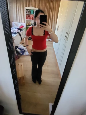 Röd croppad topp med fyrkantig ringning - Snygg röd croppad topp från Ginatricot med fyrkantig ringning och korta ärmar. Toppen har en tight passform och är gjord i mjukt stretchigt material som sitter skönt på kroppen. Perfekt att styla med höga jeans eller kjol.