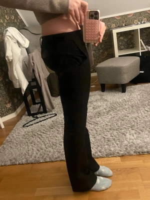 Svarta kostymbyxor från Bik Bok - Säljer ett par svarta kostymbyxor från Bik Bok med bootcut ben och låg midja. Fint skick, säljer pga att de blivit försmå i midjan💕🌟