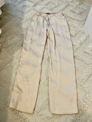 Beige satinbyxor - Snygga beige satinbyxor som aldrig är använda. Storlek S.