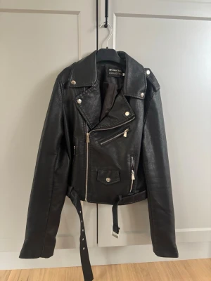 Läderjacka - En läderjacka köpt på Missäy i Göteborg. Storlek xs/s. Saknas en del av en knapp på en liten ficka men det syns inte utanpå, finns med på bild. Utöver det är jackan i bra skick och knappt använd. Två fickor med dragkedja på sidorna av jackan med rymlig plats. Perfekt för vår väder då den tål blås hyfsat bra och värms upp vid lite sol. 