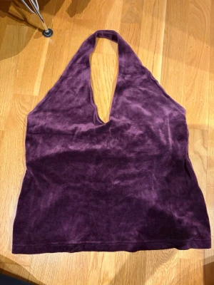 Mörklila sammets halterneck topp - Säljer en mörklila halterneck topp i mjuk sammet. Toppen har djup v-ringning och är ärmlös. Storlek XL men passar L, eller M om man vill att den ska sitta lite lösare.
