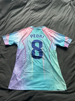 Pedri limited edition blå  - Säljer denna snygga limited edition blåa barcelona tröjan med Pedri på ryggen. Det är storlek M och skicket är nytt med tags kvar. Skriv vid frågor eller bilder