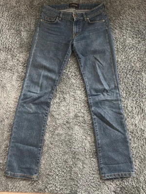Blå jeans från J.Lindeberg - Snygga blå jeans från J.Lindeberg med klassisk femficksmodell och raka ben. Jeansen har en diskret logga på myntfickan och är gjorda i slitstark denim. Perfekta för dig som gillar en tidlös och enkel stil.