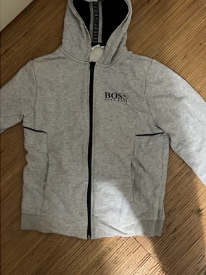 Grå zip hoodie från Hugo Boss nypris 1000kr fraktar samma dag!!  - Snygg grå kofta från Hugo Boss säljer den för 200kr snabb frakt snabb affär!! 13 till 14 år kan ha den 