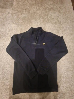 Mörkblå halfzip från Lyle & Scott - Mörkblå långärmad tröja från Lyle & Scott med halv dragkedja och ståkrage. Nästan aldrig använd. Pris kan diskuteras.