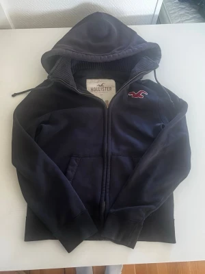 Hollister California cardigan zip hoodie (sällsynt) - Riktigt snygg och eftertraktad Hollister cardigan/zip hoodie. fint skick inga fel storlek M kan ta mått vid behov. Endast 588kr ej hugget i sten kom gärna med frågor och prisförslag har även mycket mer liknande i min profil alla storlekar kolla gärna stor rabatt vid köp av flera 😁✌️