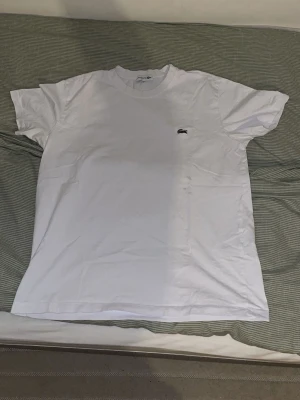 Lacoste - En vit t shirt från Lacoste skön o ha till sommarn och med märket på bröstet och väldigt bekväm o ha på sig