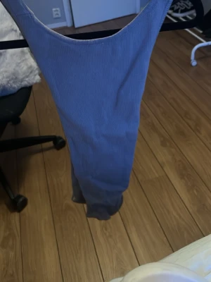 Ljusblå ribbad jumpsuit - Trendig ljusblå jumpsuit i ribbat stretchigt tyg med djup urringning både fram och bak. Figurnära passform och långa ben. Perfekt för dig som vill ha en enkel men snygg look. Materialet känns mjukt och följsamt.