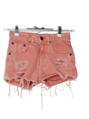 Korall färgade jeansshorts med fransar - INTRESSEKOLL på dessa söta korall färgade jeansshorts med slitna detaljer framtill. Shortsen har fransiga benslut och klassiska fem fickor. Perfekta för sommaren och ger en avslappnad vibe. Köpta på Sellpy men de är för små så har ej använt de. (Första bilder från Sellpy då jag ej har egna)