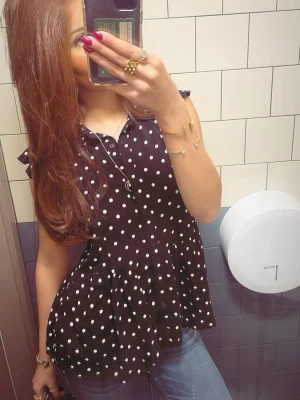 Svart prickig blus med volangärm - Säljer en svart blus med vita prickar och volangdetaljer vid ärmarna. Blusen har knappar framtill och en lätt utsvängd passform som ger en luftig känsla. Perfekt till jeans eller kjol för en trendig look.