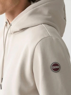 Beige hoodie från Colmar - Snygg beige hoodie från Colmar med klassisk huva och dragsko. Tillverkad i mjukt material och har en rund Colmar-logga på ärmen. Perfekt för en avslappnad och stilren look.