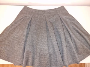 Grå kortkjol från Reserved, storlek 36 - Snygg grå kjol från Reserved i storlek 36. Kjolen har markerade veck som ger extra volym. Snygg nu till våren med tjocka strumpbyxor och boots ✨️