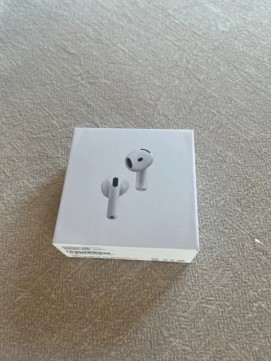 Apple AirPods 4 - Säljer ett par vita Apple AirPods med aktiv brusreducering. Snygg och stilren design i plast, perfekt för dig som vill ha trådlösa hörlurar med grymt ljud och enkel anslutning till din iPhone eller andra Apple-enheter. Använda ett fåtal gånger.