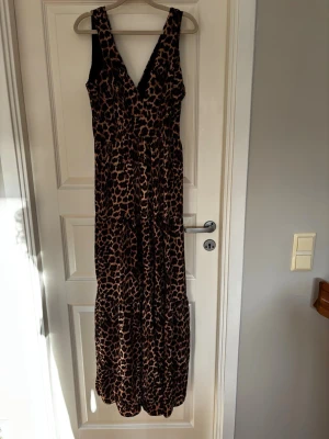 Lång leopardmönstrad klänning - Snygg långklänning med leopardmönster och djup v-ringning.