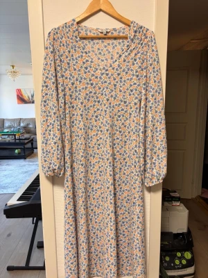 Vit sommarklänning  - Långklänning med blommigt mönster. Långärmad. Säljs inte längre, ordinarie pris 549kr.