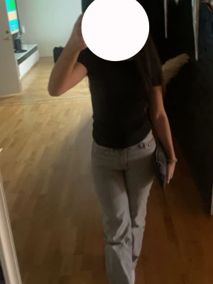 Ljusgrå raka jeans - Säljer ett par ljusgrå jeans med rak passform och lågmidja. Jeansen har klassisk femficksdesign och stängs med knapp och dragkedja. Perfekta för en avslappnad och trendig look. Mina favoritjeans men tyvärr har de blivit för små.