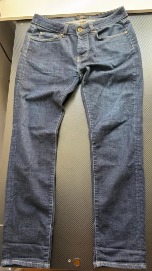 Mörkblå selvedge  - Snygga mörkblå selvedge jeans med klassisk femficksmodell och raka ben. Jeansen har kontrastsömmar och den typiska röda selvedge-detaljen vid benslutet. Tillverkade i slitstark denim med en clean look.