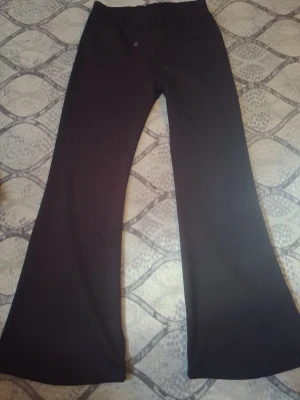 Svarta mjukisbyxor JIFI SPORT XL - Säljer ett par svarta utsvängda träningsbyxor från JIFI SPORT i storlek XL. Byxorna har resår i midjan och är tillverkade i ett stretchigt material som passar perfekt för träning eller chill. Klassisk modell med vida ben.och helt ny med pris lap på.