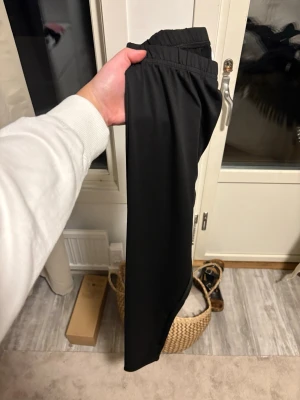 Svarta leggings med hög midja - Säljer ett par svarta leggings med hög midja och stretchigt material. De har en enkel och clean look utan synliga detaljer eller loggor, perfekta till både oversized tröjor och crop tops. Passar dig som gillar basic och bekvämt.