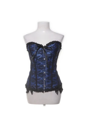 Blå och svart spetskorsett - Snygg blå korsett med svart spetsdetalj och rosett framtill. Korsetten har hakknäppning fram och snörning bak för perfekt passform. Dekorativa volangkanter och satinband ger en lyxig känsla. Köpte denna på sellpy men säljer då den aldrig kommit till användning.