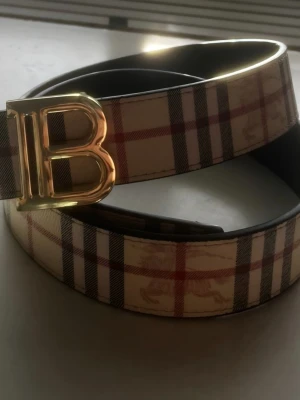 Bälte - Jätte fint bälte som man kan ha på båda sidorna. Både i begiebrun men även svart. De har fin och stilig guld logga på framsidan. Längd 105cm. Men du får även hem en metallbit som du kan göra hål i bältet med ifall de behövs. 